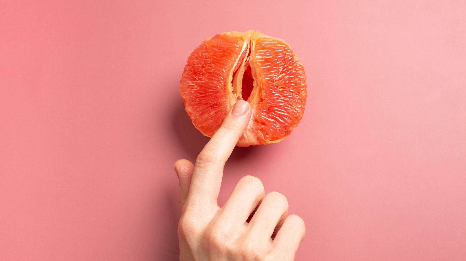 Grapefruit met vinger - roze achtergrond